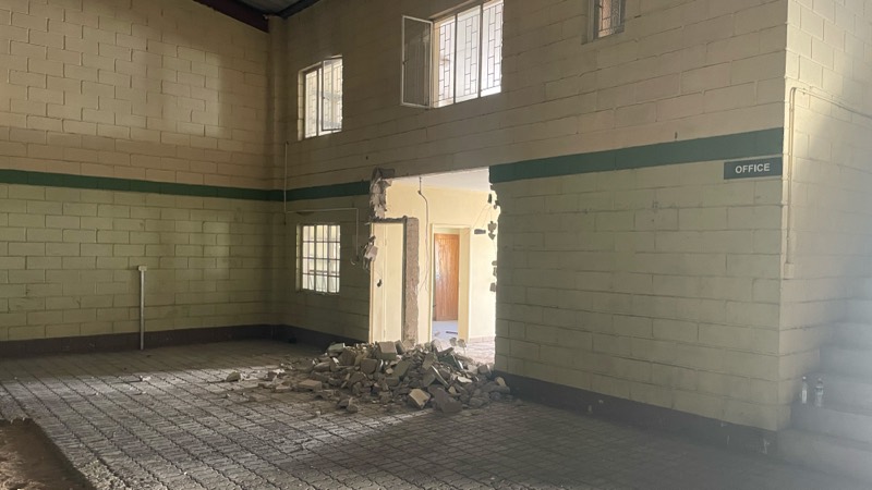 Rubble heaped against a block wall beside an office door during the strip-out.